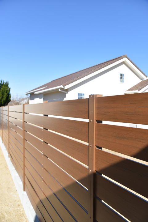 茶色の木目調の樹脂製フェンス