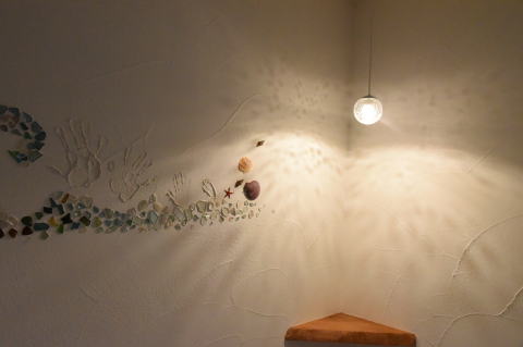 シーグラスを埋め込んだ壁を照らすコーナーペンダントライト