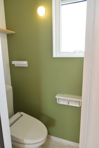 グリーンのアクセントクロスのあるトイレ