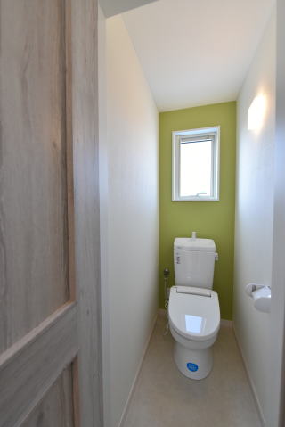グリーンのアクセントクロスのあるトイレ