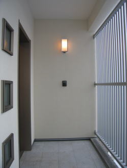 四角い小窓とグレーのアルミルーバーのある玄関ポーチ