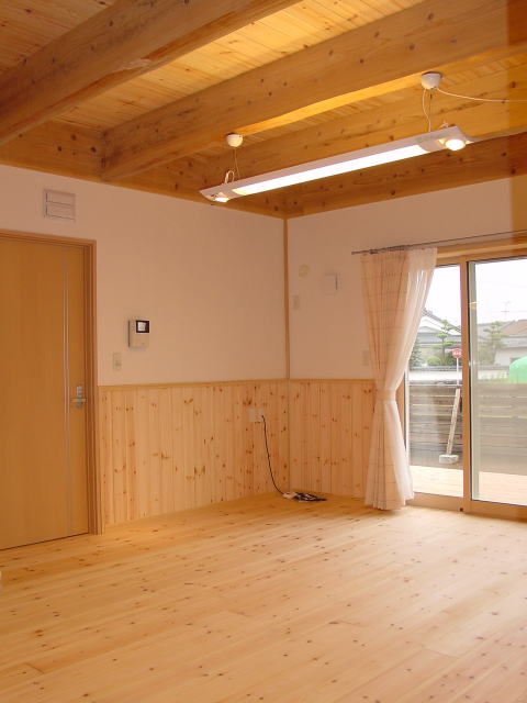 パイン無垢材の床と腰壁のリビングルーム　天井は2階床見せ