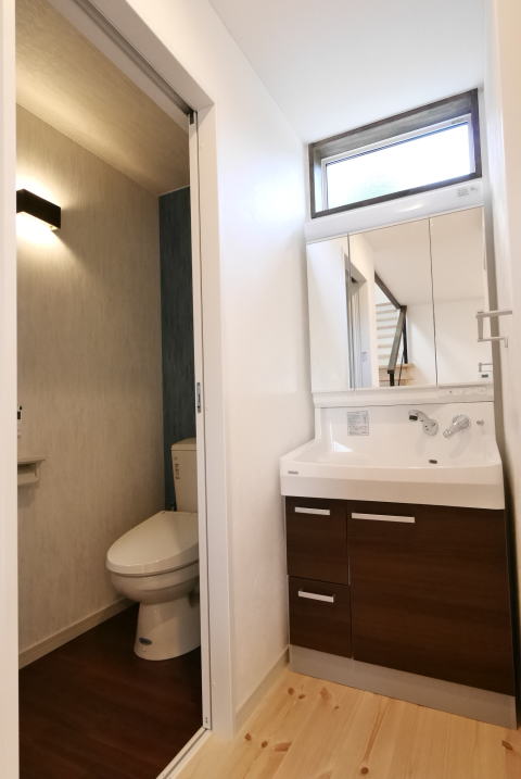 茶色い扉の洗面化粧台と洋式トイレ