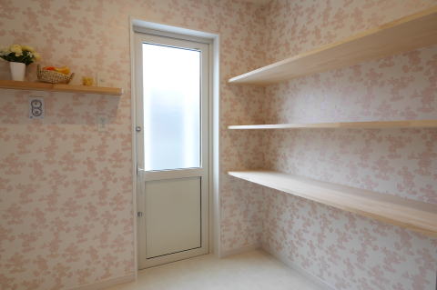 ピンクのミッキー柄クロスのある大容量収納棚の脱衣室