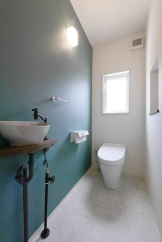 ブルーグリーンのアクセントクロスのあるトイレ