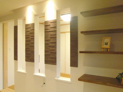 飾り棚と茶色のタイルのアクセントのある壁