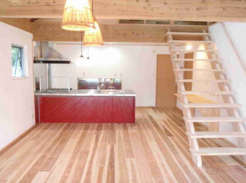 赤いキッチンと木製の階段のあるのLDK