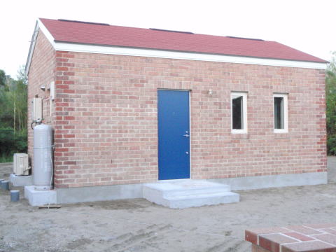 赤い屋根にレンガ積み外壁のコンパクトな家　ブルーの玄関ドア