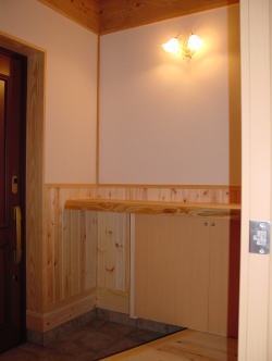 下駄箱と一枚板の木製カウンターのある玄関ホール