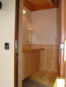 下駄箱と一枚板の木製カウンターのある玄関ホール