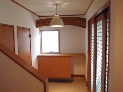 木製の下駄箱と三枚引き戸の玄関ホール